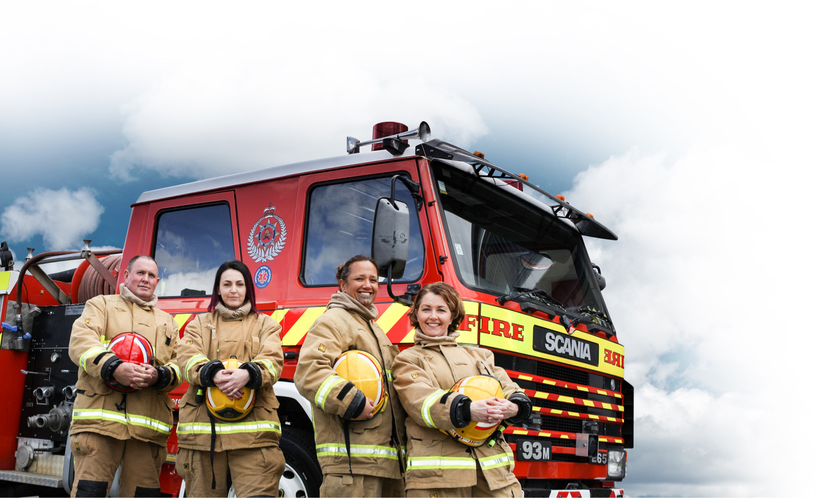 Group of firefighters in full kit standing in front of a fire engine
