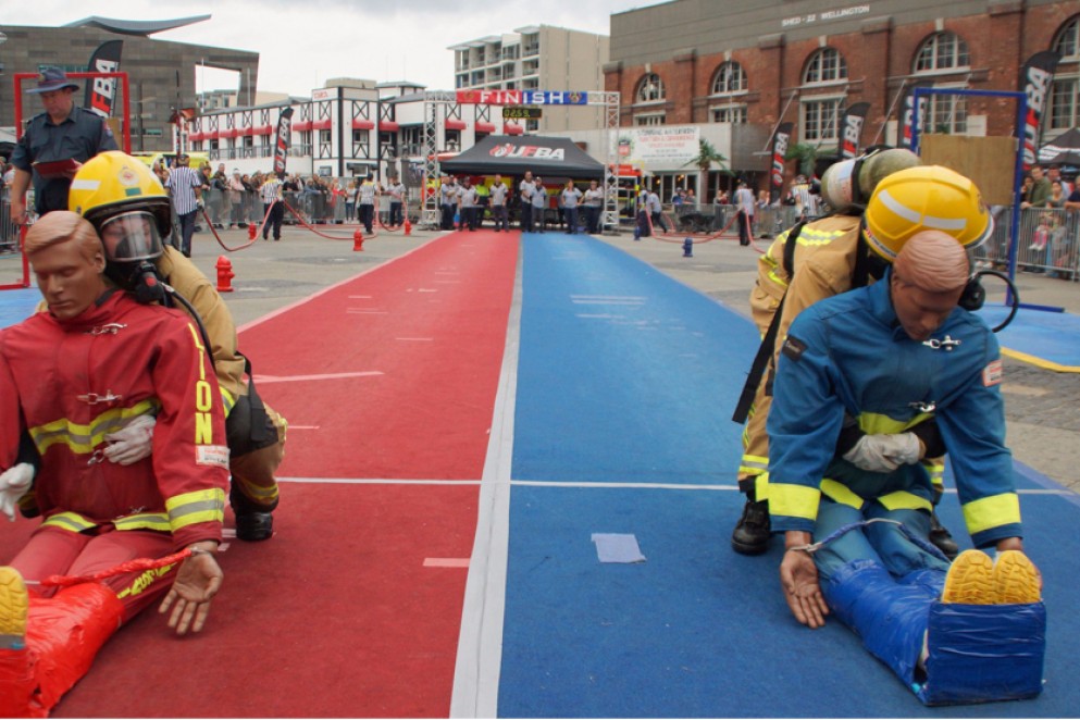 Two firefighters in full kit dragging dummies